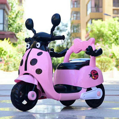 Crianças montam motocicletas elétricas de plástico em brinquedos com luzes e música